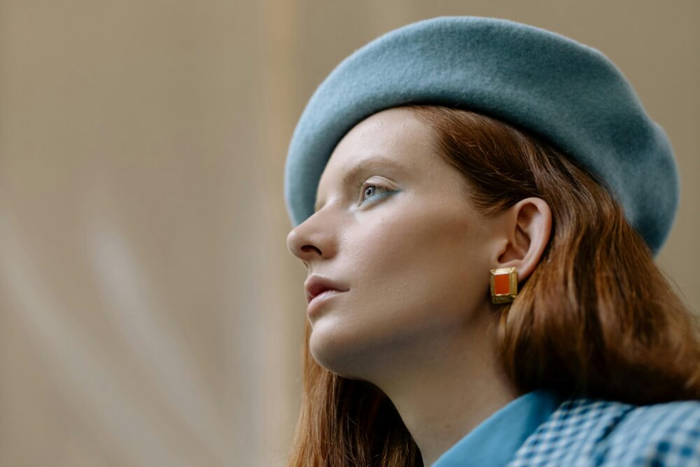 A person wearing a blue beret and a blue checkered shirt.