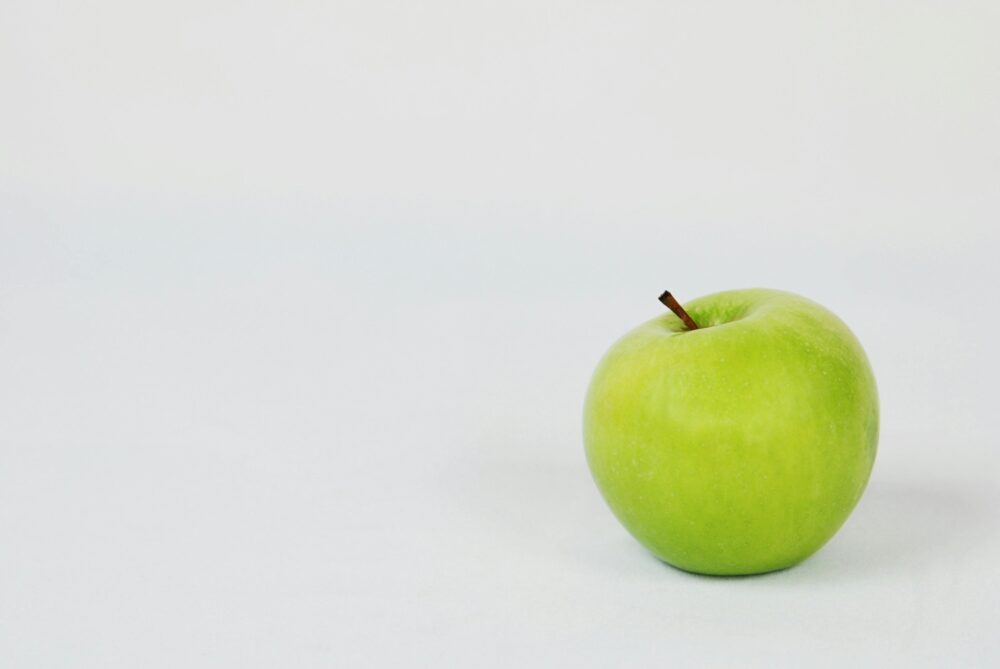 A single green apple on a plain white background.