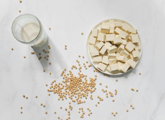 Tofu cubes, soybeans, and a glass of soy milk displayed.
